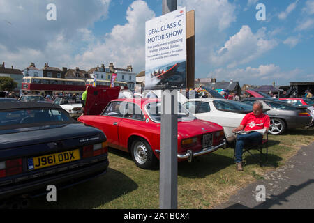 Eigentümer sitzt neben seinem roten 60er Alfa Romeo 2000 Sprint im Angebot Classic Motor Show auf Walmer Grün durch den Strand, Deal, Kent, Großbritannien Stockfoto