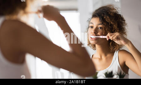 African American Girl Zähne Putzen mit der Zahnbürste im Bad, Panorama Stockfoto