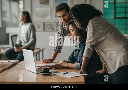 Vielfältige Gruppe von Designern zusammen auf ein Office Notebook Stockfoto