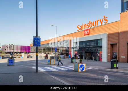 Das Stadtzentrum von Longbridge wird von Sainsbury's Superstore dominiert. Am Ende der Straße ist das Zentrum für junge Menschen in der Fabrik zu sehen. Stockfoto