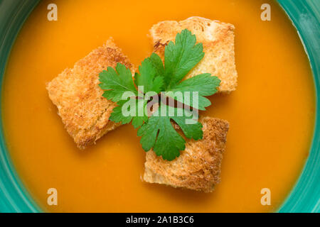 Suppe von kürbispüree und kleinen Croutons auf blauem Hintergrund. Close-up. Konzept der Herbst Menü. Stockfoto