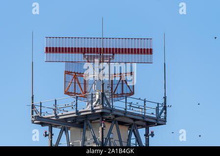 Eine Radarantenne in Betrieb am Flughafen London Heathrow, London, Großbritannien. Vögel auf Struktur und Fliegen Stockfoto