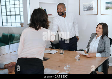 Manager die Hände schütteln mit einem Mitarbeiter während einer Konferenz Stockfoto