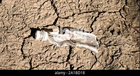 Kunststoff Flasche auf dem Schlamm Bank die Hälfte brach von der Sonne und mechanische Einwirkungen Stockfoto