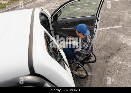 Behinderte Menschen im Rollstuhl durch ein Auto Stockfoto