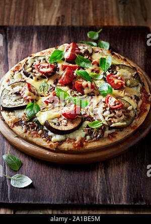 Aubergine und Tomate Pizza mit Basilikum. Italienische Pizza. Hausgemachte Speisen. Stockfoto