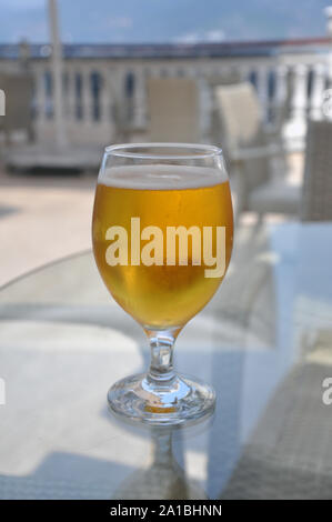 Wein Glas mit kleinen Tropfen Kondenswasser auf der Außenseite der Glas und mit goldenen Bier gefüllt Stockfoto