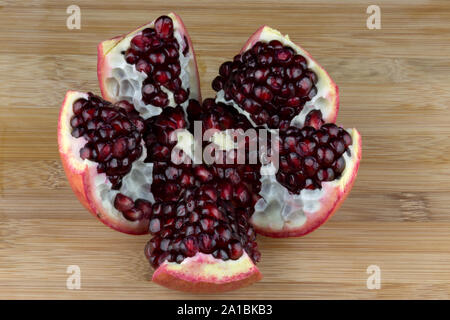 Frisch geöffneten Granatapfel auf einer hölzernen Tischplatte Stockfoto