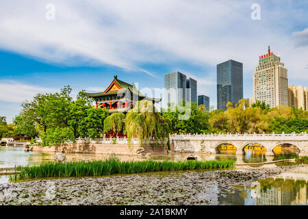 Urumqi Renmin Gongyuan People's Park atemberaubenden See Pavillon mit Wolkenkratzern im Hintergrund auf einem sonnigen blauen Himmel Tag Stockfoto