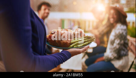 Gruppe von diversen Freunden beim Abendessen im Freien im urbanen Umfeld Stockfoto