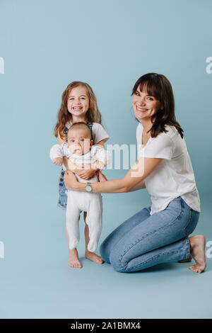 Family Portrait einer Mutter mit zwei Töchtern über blauer Hintergrund Stockfoto