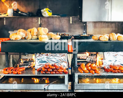 Weihnachtsmarkt in Deutschland, in Europa. Traditionelle bratwurst Wurst und Brot auf Grill während der saisonalen Weihnachtsmarkt in München Stockfoto