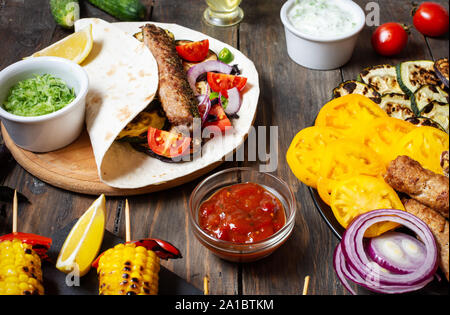 Verschiedene köstliche gegrillte Gemüse und Döner auf einer hölzernen Hintergrund. Sommer essen Grill. Stockfoto
