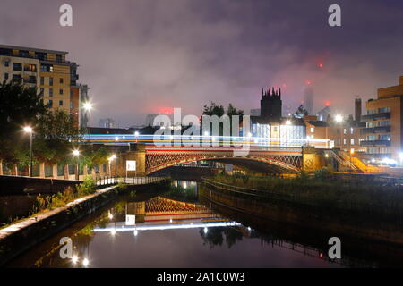 Eine Ansicht von Leeds aus Leeds Dock am frühen Morgen. Altus House ist Yorkshire höchstes Gebäude und können direkt hinter Leeds Münster gesehen werden. Stockfoto