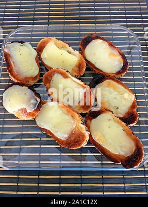 Käse auf Toast Scheiben auf einer Glasplatte Stockfoto