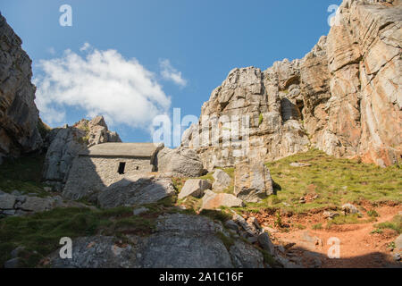 St. Govan's Chapel, mittelalterlichen Wallfahrtskapelle, bei St. Govan's Kopf, Pembrokeshire in South West Wales, UK. In die Seite eines Kalkstein erbaute Gebäude Maßnahmen 20 bis 12 Fuß (6,1 m × 3,7 m). Die Mehrheit der Kapelle wurde im 13. Jahrhundert gebaut, obwohl es zurück Datum kann sich auf dem sechsten Jahrhundert bei St. Govan, ein Mönch in einer Höhle auf dem Gelände der Kapelle verschoben Stockfoto