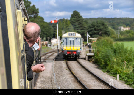 Gloucestershire, ENGLAND - SEPTEMBER 2019: Eisenbahnliebhaber lehnen sich aus dem Fenster eines Zuges, um einen Diesel-Mehrteilerzug zu sehen Stockfoto