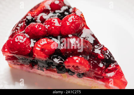 Stück Kuchen mit Beeren: Himbeere, Erdbeere, Johannisbeere, auf einem weißen Hintergrund, Nahaufnahme Stockfoto