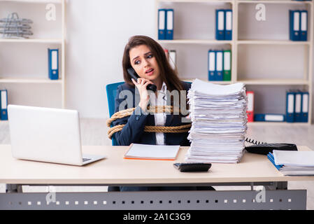 Die junge schöne Mitarbeiter gebunden mit Seil im Büro Stockfoto