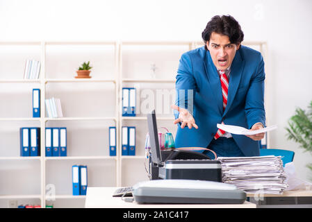 Der junge Arbeitnehmer Kopien beim Kopieren von Maschine Stockfoto