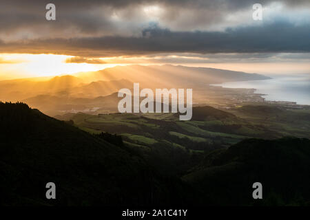 Atemberaubenden Sonnenuntergang Blick auf die vulkanische Landschaft auf der Insel São Miguel auf den Azoren Archipel. Vulkankegel sind durch Sonnenstrahlen beleuchtet. Stockfoto