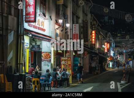 Singapur - Februar 8, 2019: Chinesen haben Abendessen in Street Cafe in der Nacht in Chinatown Stockfoto