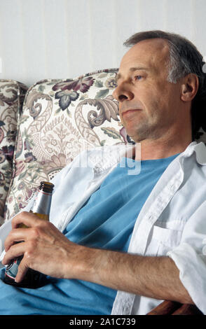 Unglücklich reifer Mann mit einer Flasche Bier Stockfoto