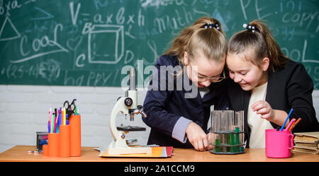 Studium der Chemie interessant machen. Grundkenntnisse der Chemie. Schüler nette Mädchen Röhrchen mit Flüssigkeiten verwenden. Chemie experiment Konzept. Sicherheitsmaßnahmen für die sichere chemische Reaktion. Stockfoto