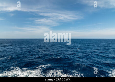 Hintergrund Meer mit kleinen Wellen und den Schaumstoff und die Himmel mit Wolken Stockfoto