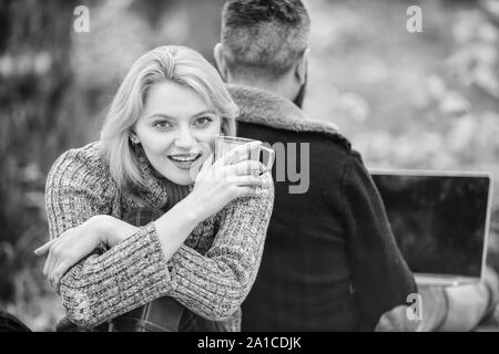 Sagen Sie Nein zu Office Routine. Familie Picknick. Beziehung. glückliches Mädchen trinken heißen Kaffee oder Wein. Mann Sitzen mit zurück. Frühling Stimmung. Camping und Wandern. verliebtes Paar im Herbst Wald mit Computer entspannen. Stockfoto