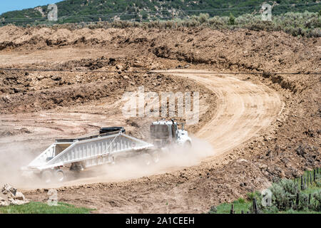 Meeker, USA - Juli 22, 2019: Canyon die Berge in der Nähe Gewehr, Colorado mit Lkw während der Bauarbeiten auf der Piste mit Staub vor Ort Stockfoto