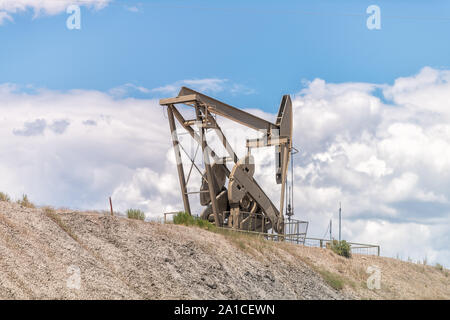 Rangely, USA - 22. Juli 2019: Colorado City mit Nahaufnahme des Hill Bau unterzeichnen und Pumpe buchse Bohren nach Öl gegen himmel isoliert Stockfoto