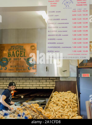 Ein Arbeiter entfernt frische Bagels aus dem Ofen in St. Viateur Bagel in Montreal, Kanada. Stockfoto