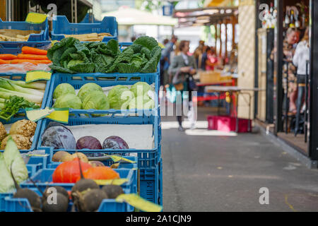 Verschiedene Gemüse verkaufen auf Reihe von Kunststoff blau Warenkorb vor der Abschaltdruck außerhalb Lebensmittelgeschäft neben Flur der Open-Air-Markt. Stockfoto