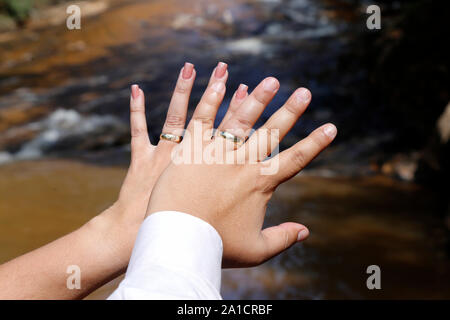 Pflegt Hände verbunden mit Hochzeit Ringe - Goldene Hochzeit Ringe Stockfoto