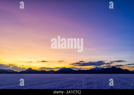 Weitwinkelaufnahme der Bonneville Salt Flats in der Nähe von Salt Lake City, Utah in der Dämmerung nach Sonnenuntergang mit lila und blau Himmel und Horizont Stockfoto