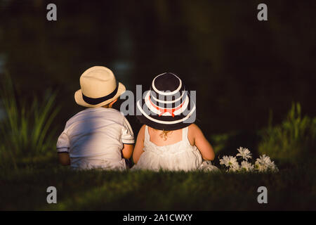 Zwei Kinder Sitzen am Teich Stockfoto