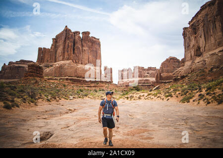 Mitte alter Mann ist Wandern unter den roten Felsen von Arches National Park Stockfoto