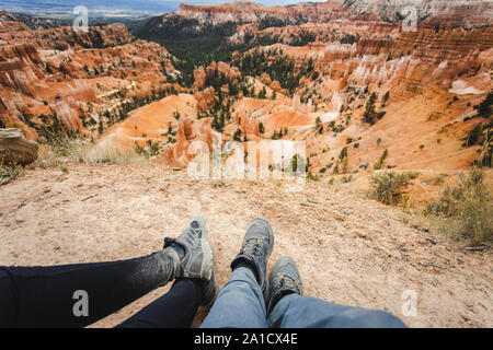 Erster Blick auf den männlichen als weiblichen Füße in einer staubigen geschlagen Wanderschuhe mit einem schönen Red Canyon in den Hintergrund Stockfoto