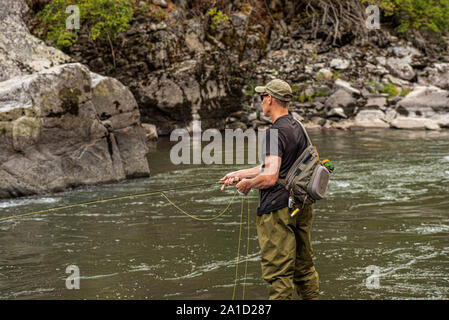 Fischer Casting im Gebirgsbach Fliegen. Stockfoto