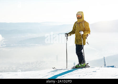 Skifahrer mit Ski auf dem Berg oben am Beginn der Steigung Stockfoto