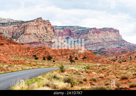 Auto auf der Straße Autobahn im Capitol Reef National Monument mit gepflasterte Strasse und bunten Steinen und Felsen Stockfoto