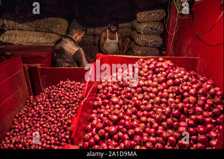 Kolkata, Indien. 25 Sep, 2019. Arbeiter arbeiten bei einer Zwiebel Großhandelsmarkt in Kolkata, Indien, Sept. 25, 2019. Preis der Zwiebeln haben stieg auf fast das Dreifache in den letzten paar Wochen in Indien, angeblich wegen der schweren Schäden zu erbringen bereit - für - Ernte Ernte im südwestlichen Bundesstaat Maharashtra und anderen nahe gelegenen Gebieten, durch die unaufhörlichen Regenfälle in diesem Jahr. Verkauft bei einem Preis von rund 20 indische Rupien ein Kilogramm in Delhi und anderen Teilen im Norden von Indien, die Ware wird jetzt bei fast 60 Indische Rupien ein Kilogramm erhältlich. Credit: tumpa Mondal/Xinhua/Alamy leben Nachrichten Stockfoto