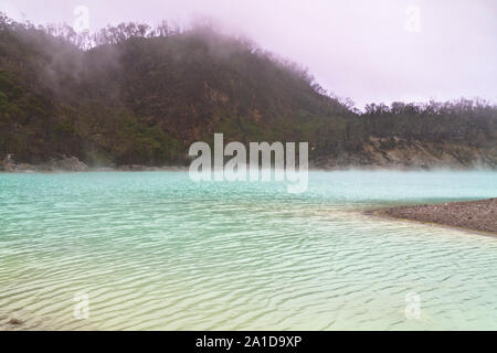 Nebel bilden auf dem blauen vulkanischen Kratersee Oberfläche Stockfoto