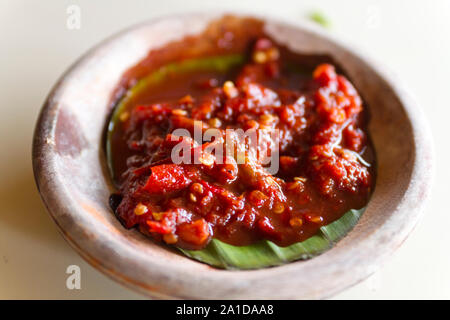 Chili Paste oder Sambal aus frischem rotem Chili, serviert auf bananenblatt auf eine keramische Schüssel Stockfoto