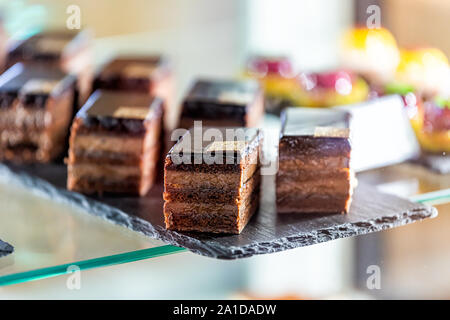 Nahaufnahme von Schokolade Layer Cake slices Gebäck auf Fach Anzeige in Bäckerei shop shop in Florenz, Italien, in der Nähe des berühmten Markts Stockfoto