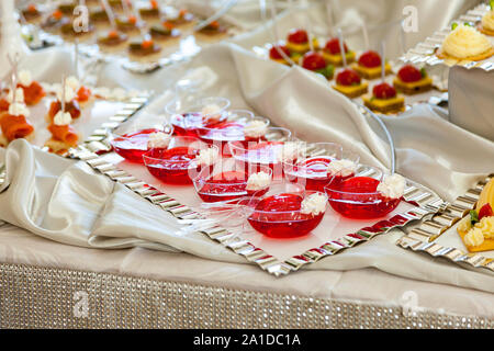 Himbeere Jello mit frischen Früchten auf einem festlich gedeckten Tisch Stockfoto