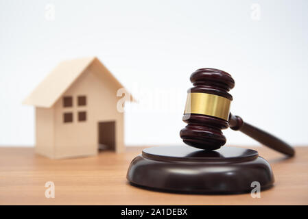 Auktion oder Gesetz Konzept. Miniatur Haus auf Holztisch und Richter Hammer. Stockfoto