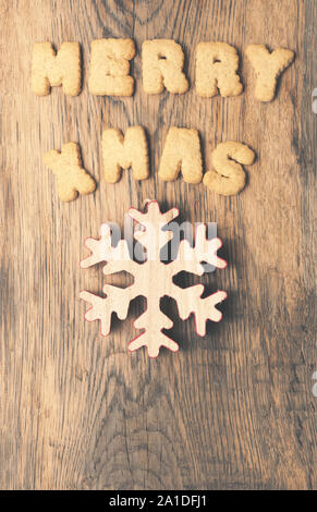 Weihnachtsbaum Form der Tannenzapfen mit den Worten Merry X-Mas auf einem rustikalen Holzbrett Stockfoto