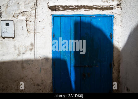 Geformte Schatten auf eine blaue Tür in Essaouira, Marokko, Afrika Stockfoto